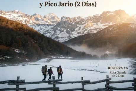 Aquí tienes un texto alternativo breve, descriptivo y optimizado para SEO (SEO-friendly) para tu página de WooCommerce: Tres senderistas caminan por el nevado paisaje de Vegabaño frente al Pico Jario y el Cornión al amanecer, en una imagen promocional para la reserva del trekking de 2 días.